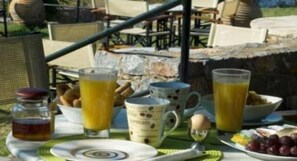 Una mesa con platos, vasos y una botella de jugo para el desayuno.