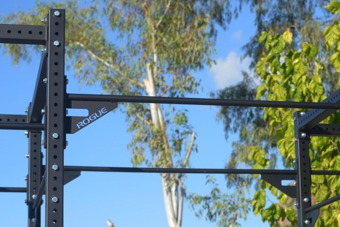 A metal structure with a "ROGUE" label, likely part of a gym or fitness equipment.