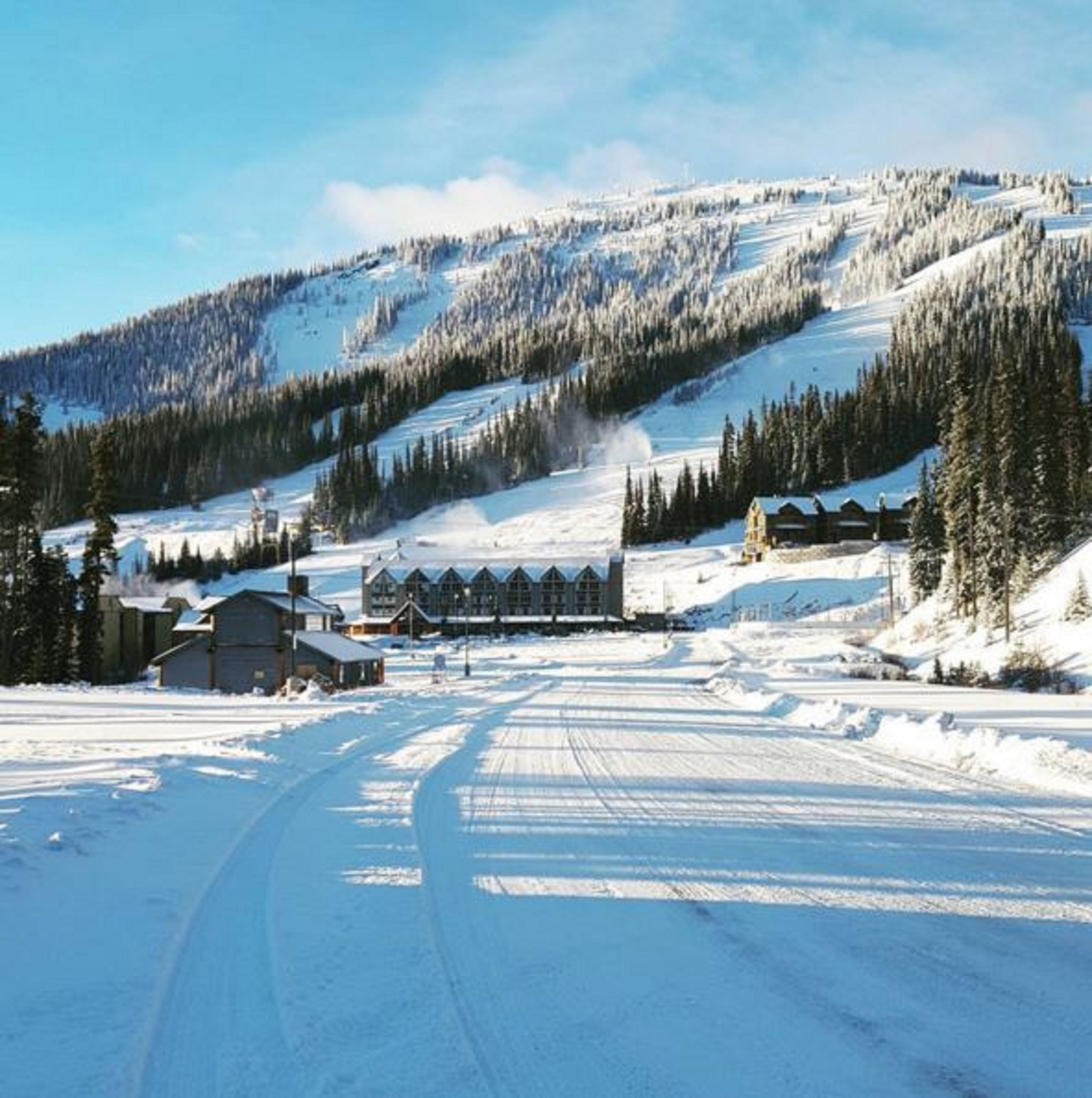 A snow-covered landscape with a lodge and a ski slope.