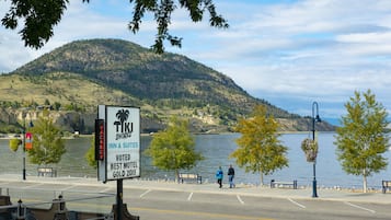 Une enseigne indiquant l’hôtel « Tik Shore Inn & Suites », avec en arrière-plan une vue sur un lac et des montagnes.