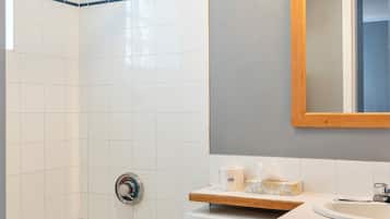 Un baño con bañera, inodoro y tocador con espejo.