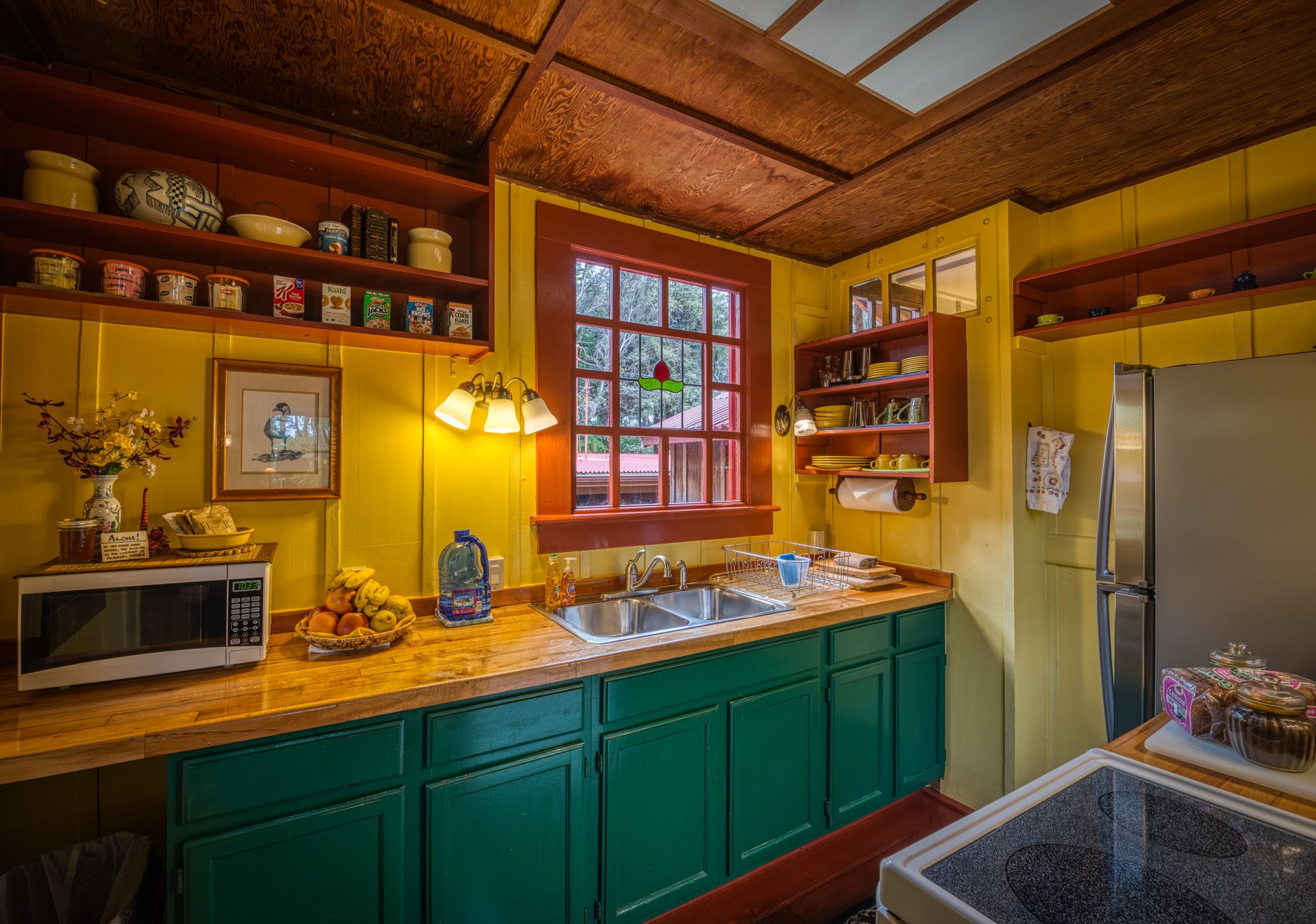 A kitchen with wooden cabinets, a refrigerator, a sink, and various kitchen appliances.