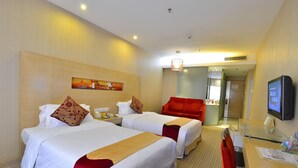 A hotel room with two beds, a red chair, a desk with a computer, and a TV. - Sunon Hotel (Shenzhen)