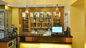 A hotel lobby with a reception desk, a chandelier, wine racks, and a computer monitor. - Sunon Hotel (Shenzhen)