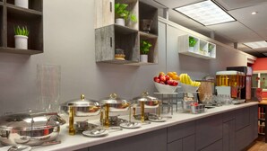 Una mesa de buffet con diferentes alimentos y utensilios.
