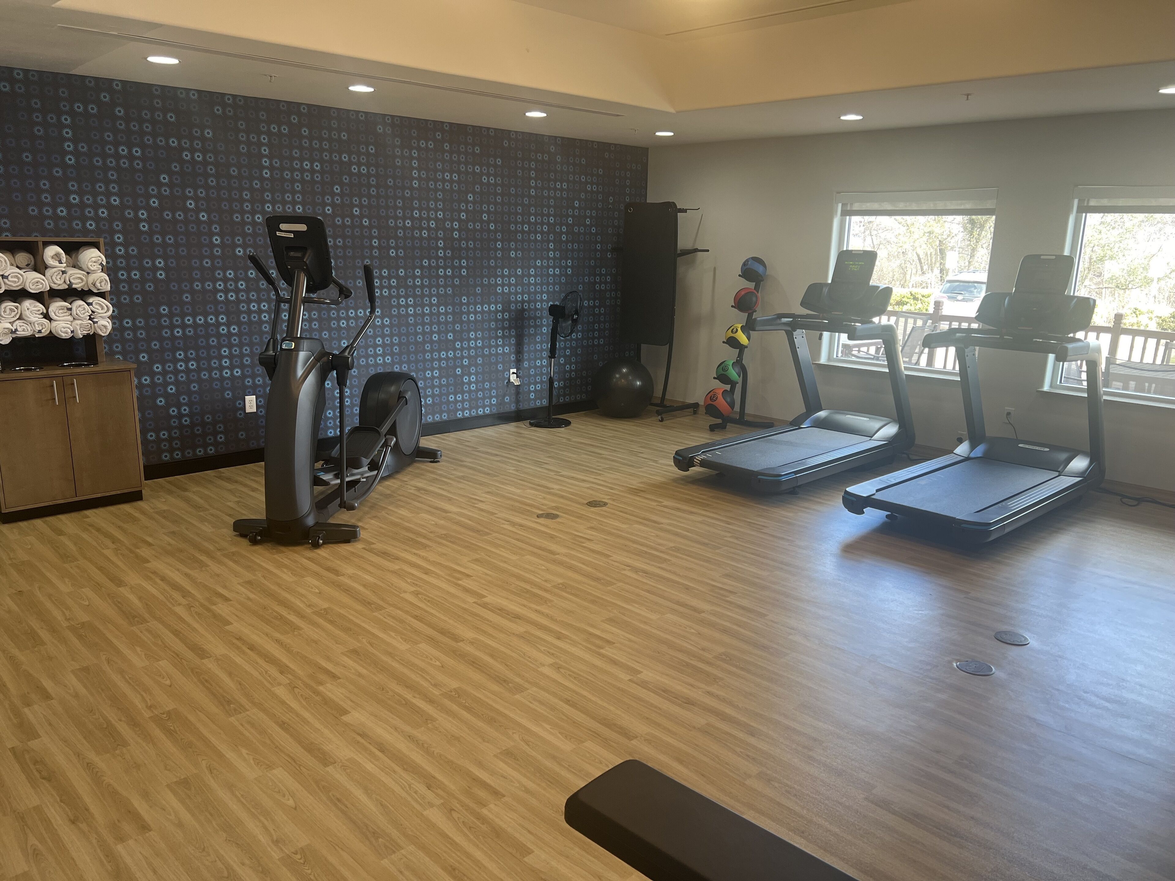 A gym with treadmills, an elliptical, and a stationary bike.