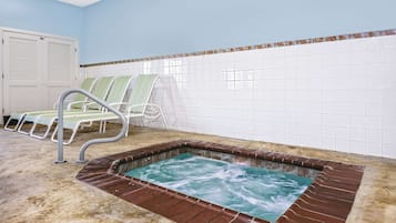Una piscina techada, sillones reclinables de piscina