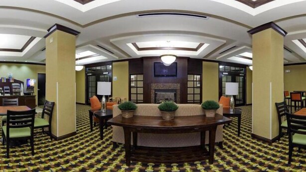 A hotel lobby with a round table, sofas, and a fireplace. - Holiday Inn Express Hotel & Suites Richwood-Cincinnati South by IHG (Walton)