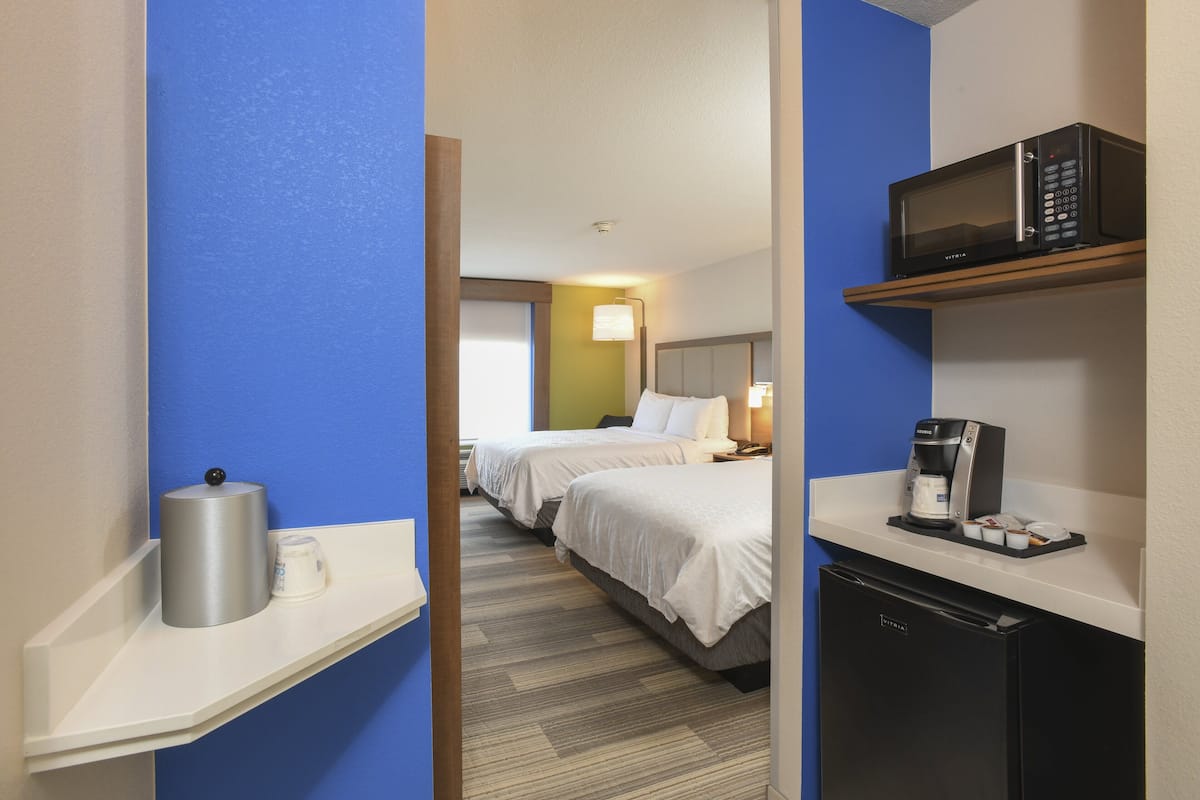 Une chambre d’hôtel équipée d’un lit, d’un four à micro-ondes, d’une machine à café et d’un mini-réfrigérateur.