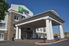 A Holiday Inn Express & Suites building with a covered entrance and a brick facade. - Holiday Inn Express Hotel & Suites Richwood-Cincinnati South by IHG (Walton)