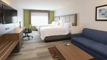 Habitación de hotel con cama, sofá, escritorio y televisión.