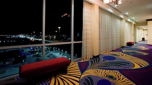 A hotel room with large windows, a patterned carpet, and a red bench. - Houston Marriott Energy Corridor (Houston)