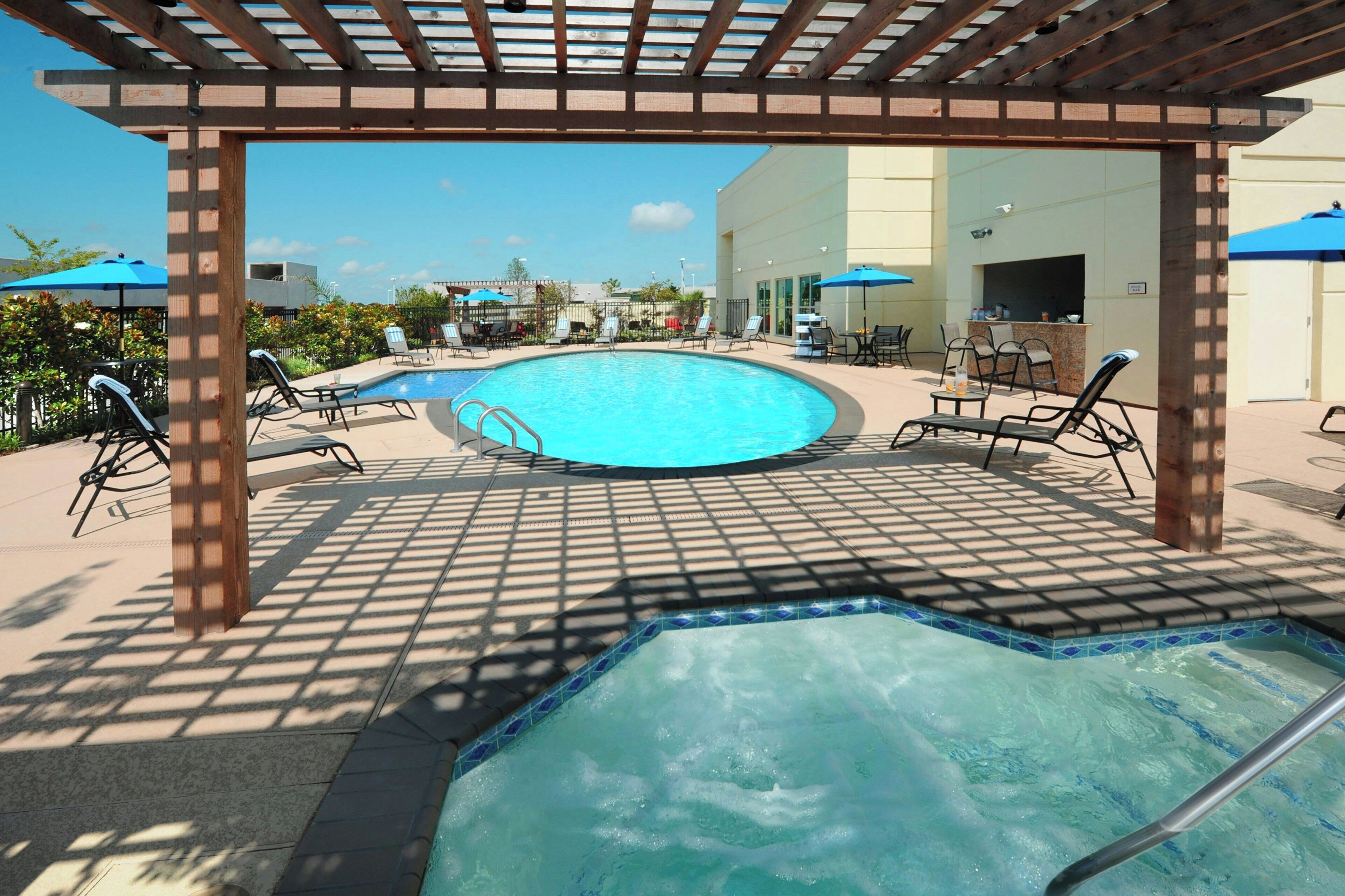 Alberca al aire libre, sombrillas en la alberca y camastros 