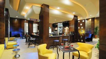 Eine Hotelhalle mit Barbereich, Sitzgelegenheiten und einem Starbucks-Kaffeebereich.