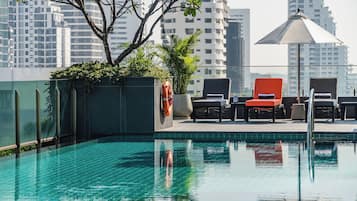 Alberca al aire libre, sombrillas en la alberca y camastros