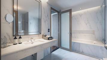 A modern bathroom with a marble vanity, a large mirror, and a glass-enclosed shower.