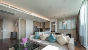 A modern living room with a sofa, coffee table, and artwork on the walls. - MUU Bangkok, Small Luxury Hotels of the World (Bangkok)