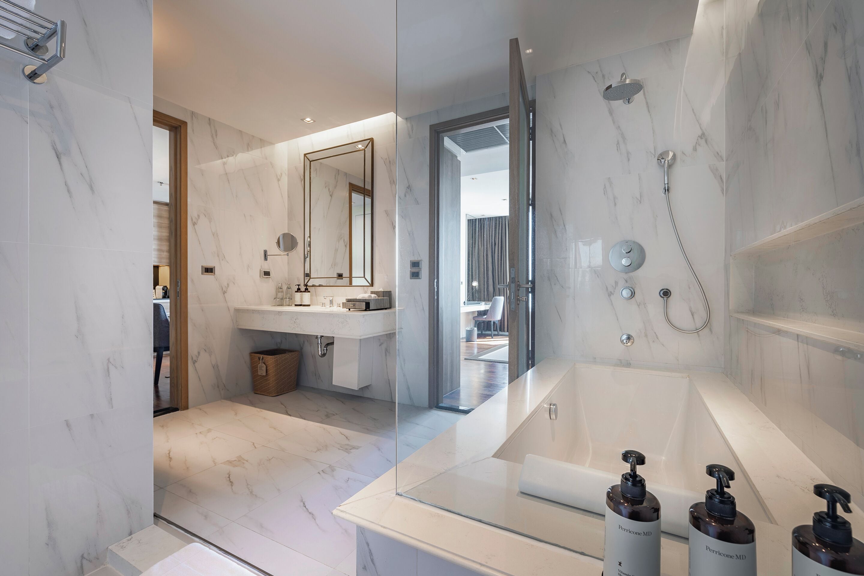 A modern bathroom with a glass-enclosed shower, a large bathtub, and a vanity with a mirror.