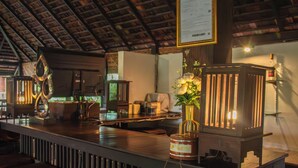 A bar area with a menu sign, decorative lanterns, and a wooden counter. - Sunday Rainforest Chiangmai Hotel  (Chiang Mai)