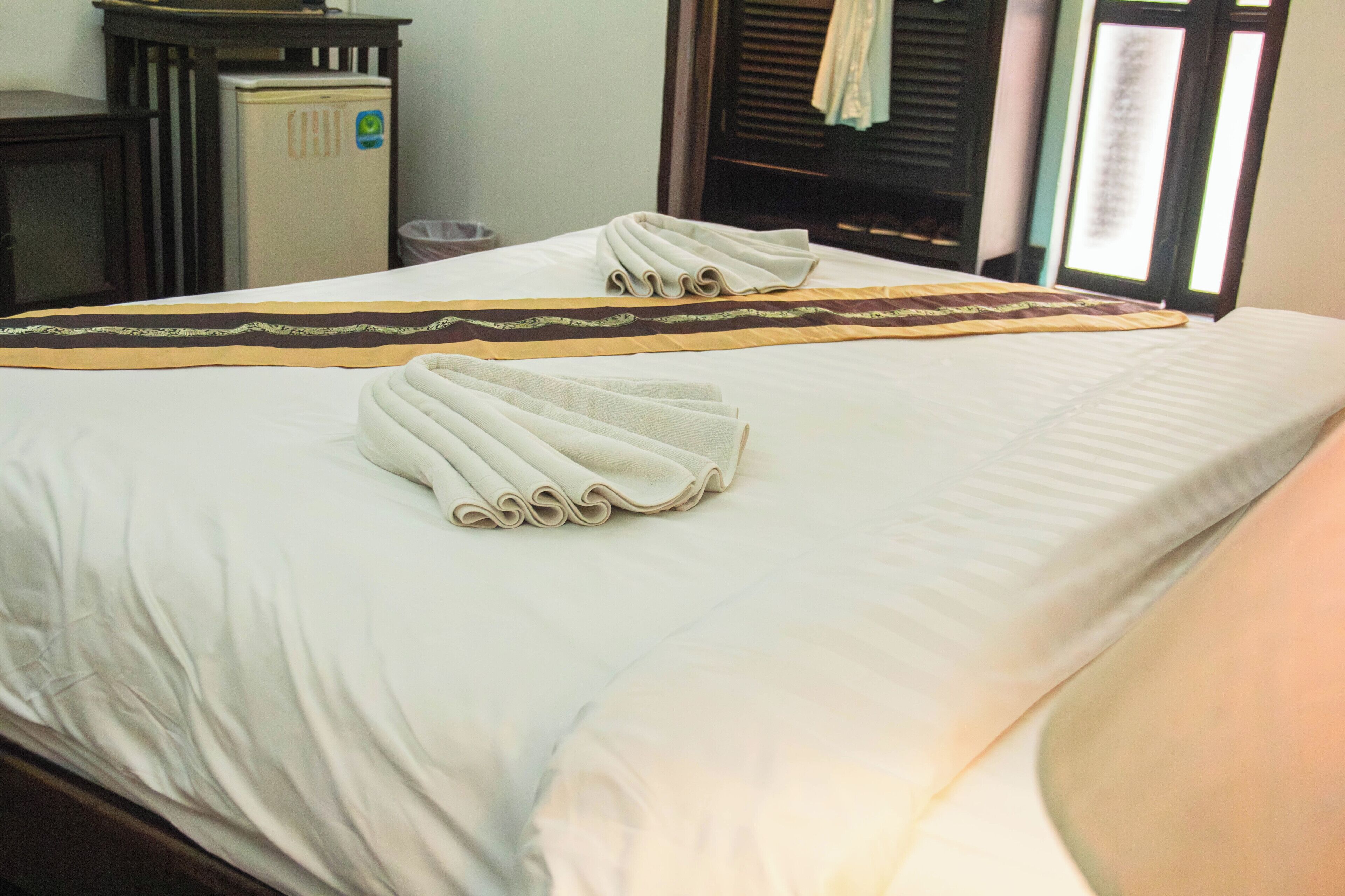 Een hotelkamer met een bed, een klein tafeltje en een stoel.