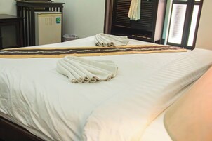Una habitación de hotel con cama, una mesita y una silla.