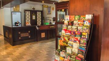 A reception desk with a magazine rack filled with travel and adventure books.