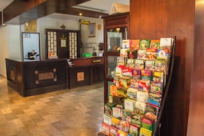 Una mesa de recepción con un atril lleno de libros de viajes y aventura.