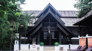 A resort with a swimming pool, lounge chairs, and a building with a distinctive triangular roof. - Sunday Rainforest Chiangmai Hotel  (Chiang Mai)
