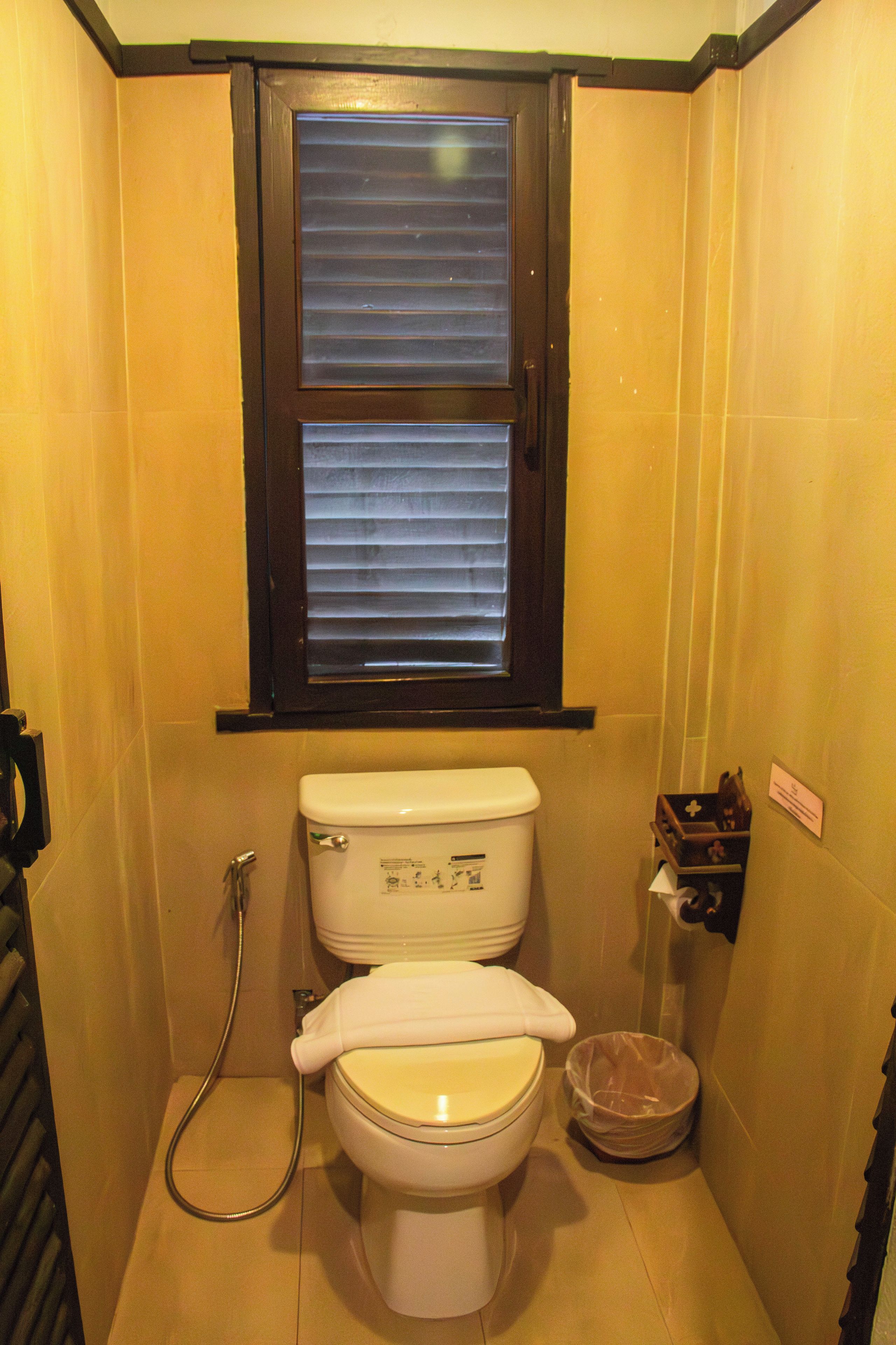 Un baño pequeño con inodoro, ventana y ducha.