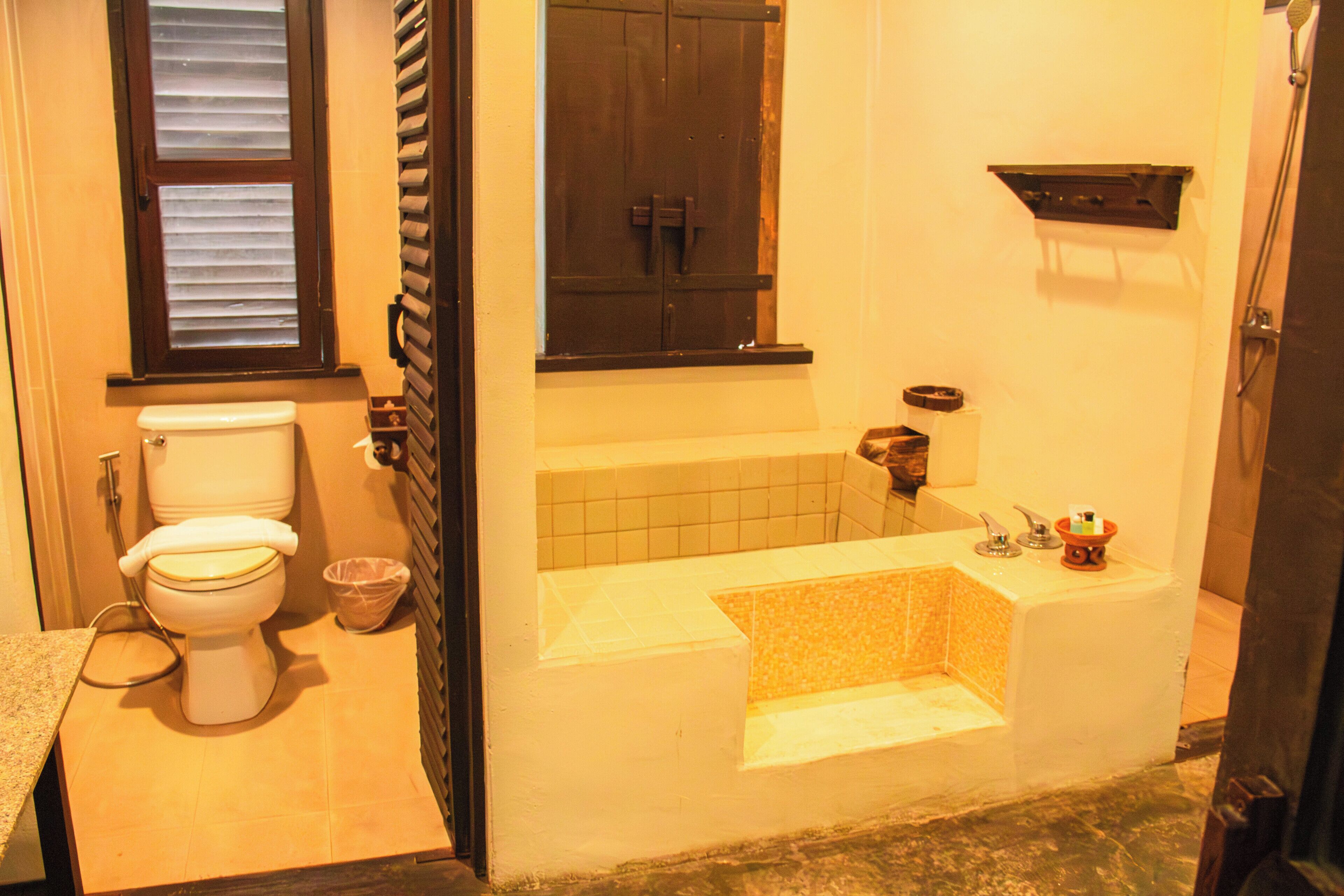 A bathroom with a toilet, a bathtub, and a shower.