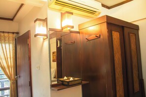 Un baño con tocador de madera, un espejo y un perchero para toallas.