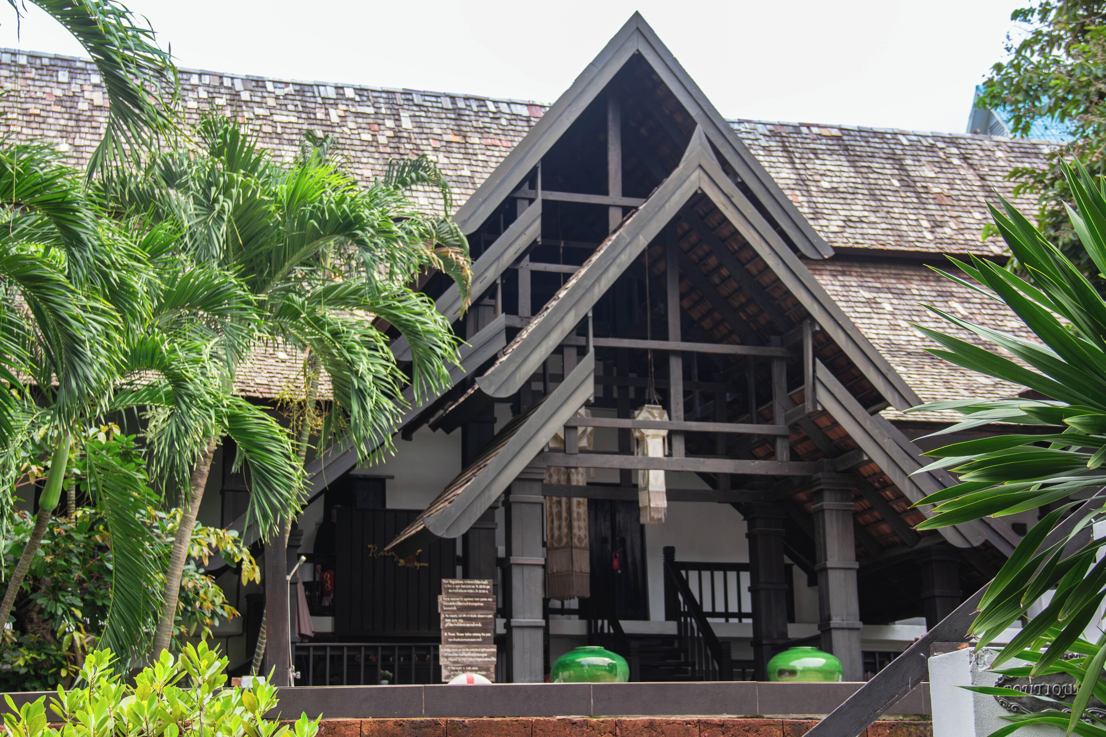 A building with a distinctive triangular roof and a staircase leading to the entrance.