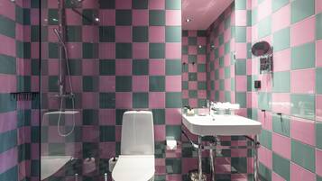 A bathroom with a checkered tile pattern, a toilet, a sink, and a shower.