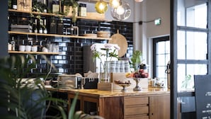 A modern kitchen with wooden countertops, a central island, and various kitchen appliances. - Hotel Flora (Gothenburg)