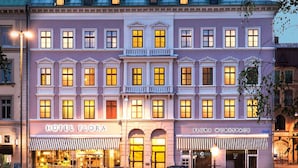 A hotel with a classic facade, featuring a central entrance with a balcony, and two storefronts labeled "Hotel Flora" and "Flora Workspace". - Hotel Flora (Gothenburg)