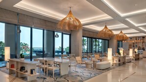 A modern hotel lobby with large windows, a central seating area, and decorative lighting. - Crowne Plaza Abu Dhabi Yas Island by IHG (Abu Dhabi)