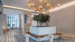 A modern lobby with a reception desk, patterned carpet, and hanging wicker lamps. - Crowne Plaza Abu Dhabi Yas Island by IHG (Abu Dhabi)