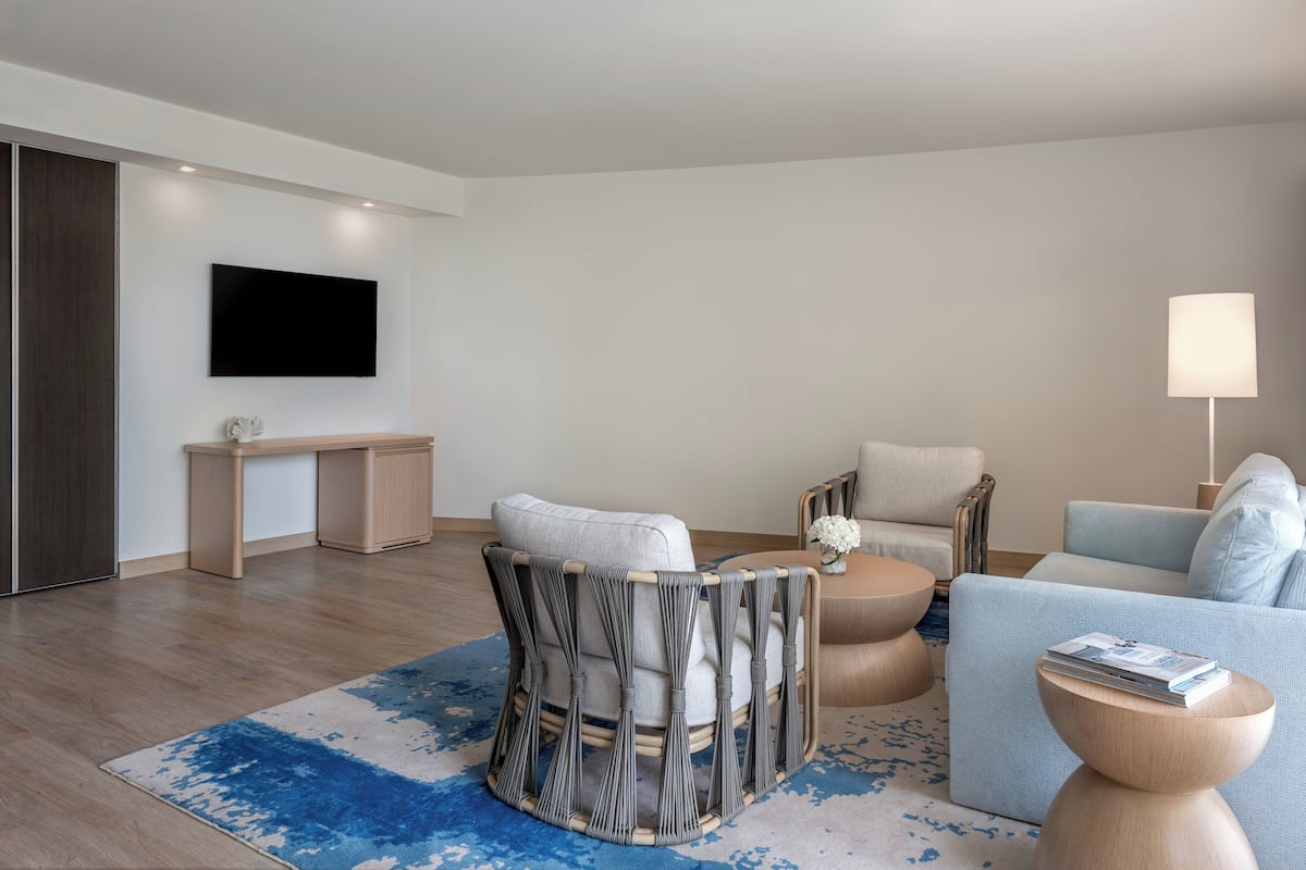 A modern living room with a sofa, armchair, and round coffee table.