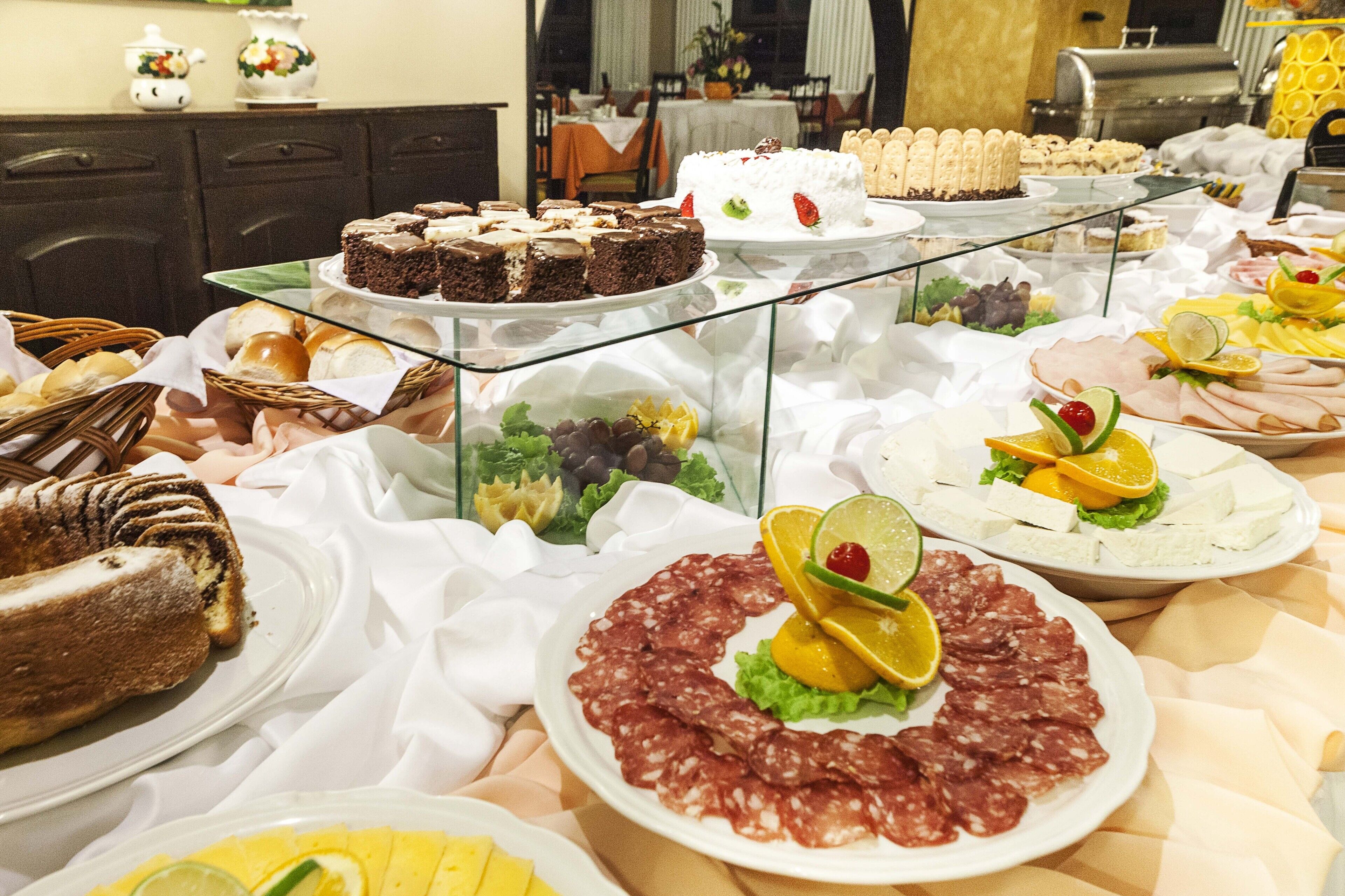 A buffet with various food items including cakes, pastries, and meats.