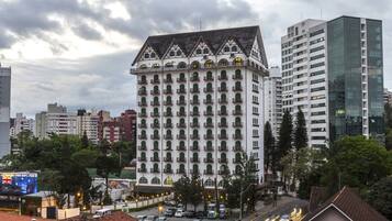 Un hotel de varios pisos con estilo arquitectónico clásico, que cuenta con un patio central y balcones.