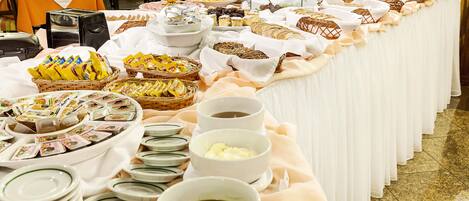 Una mesa de buffet con diferentes alimentos y bebidas.