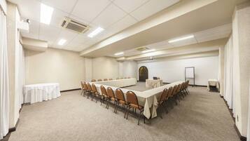 A conference room with a long table and chairs, a whiteboard, and a projector.