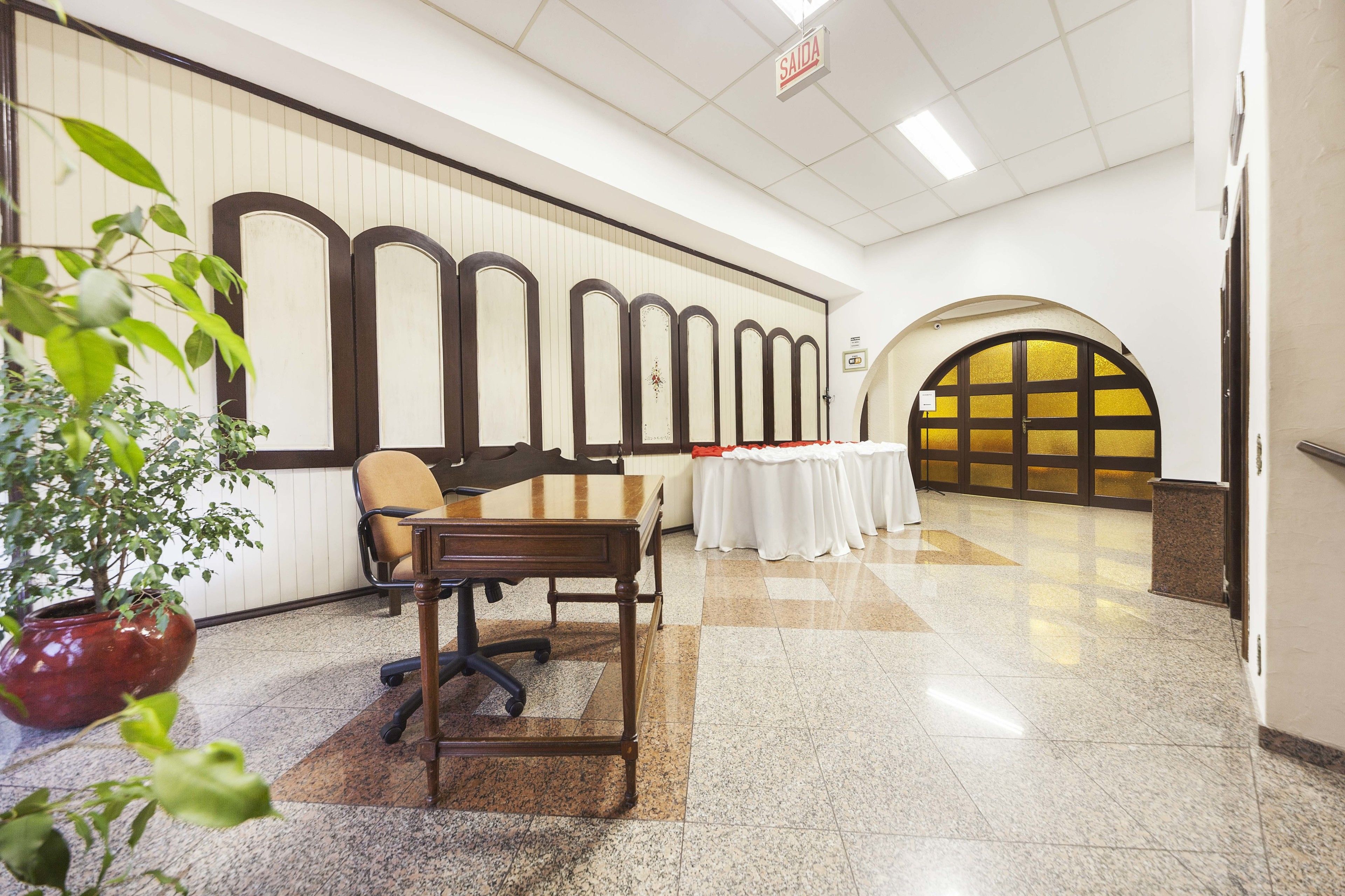 Vestíbulo de hotel con mostrador de recepción, zona de estar y una pared decorativa.