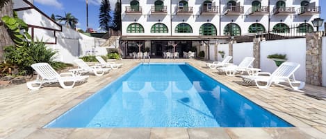 Una piscina al aire libre, tumbonas