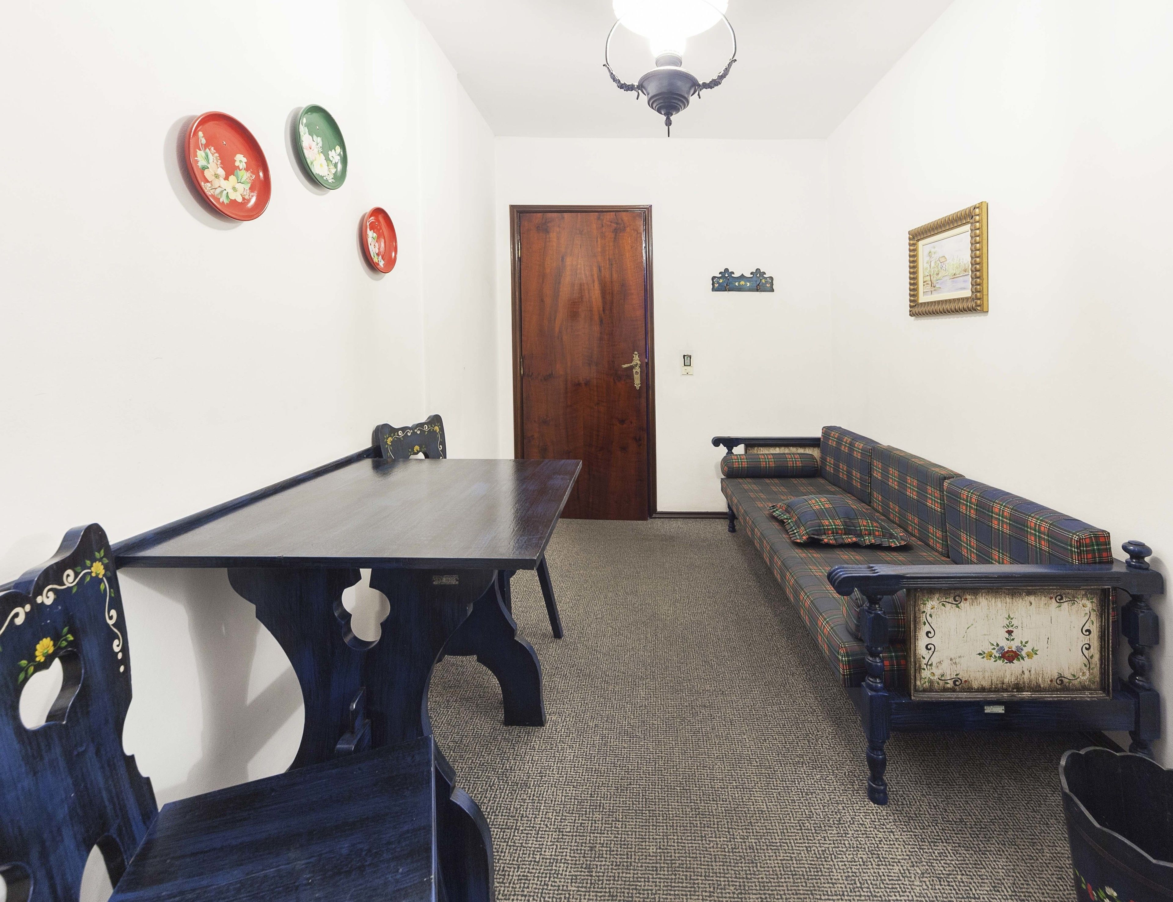 A room with a wooden table, a sofa, and a door.