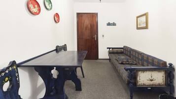 A room with a wooden table, a sofa, and a door.