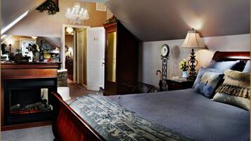 Ein Schlafzimmer mit einem großen Bett, einem Schminktisch, einem Schreibtisch und einer Kandelaber.