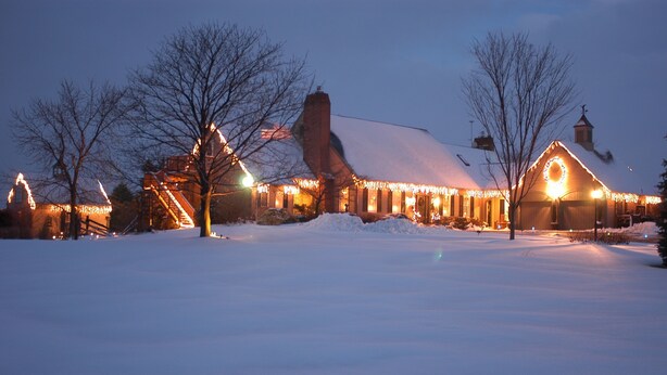 A snow-covered landscape with a building featuring a large circular window and a snow-covered roof.