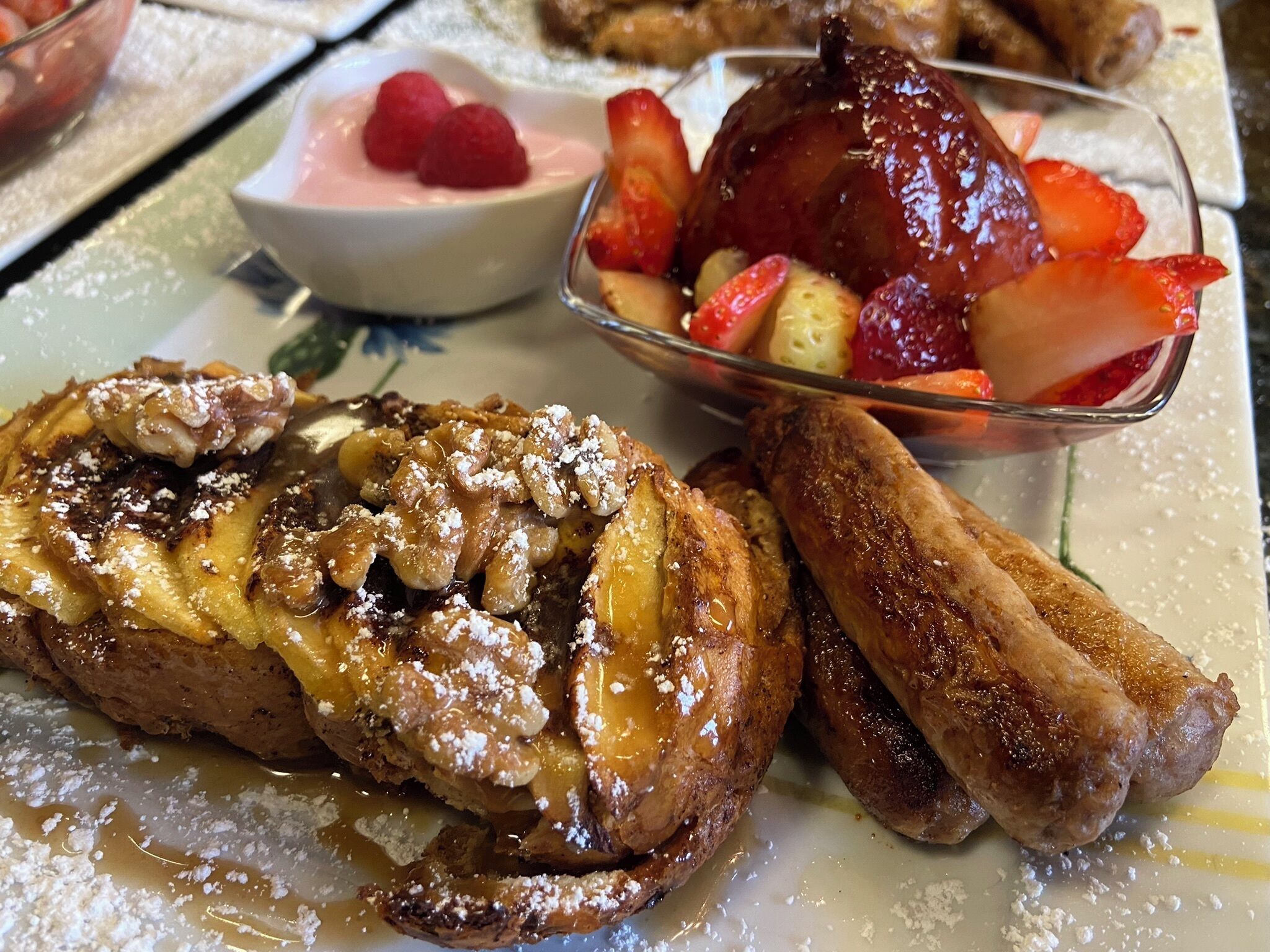 Prato de café da manhã com torradas francesas, uma tigela de frutas e um copo de leite.