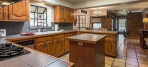 A spacious kitchen with wooden cabinets, a large island, and a built-in dishwasher.